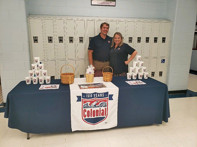 A picture of two Colonial employees at a recruiting fair. 